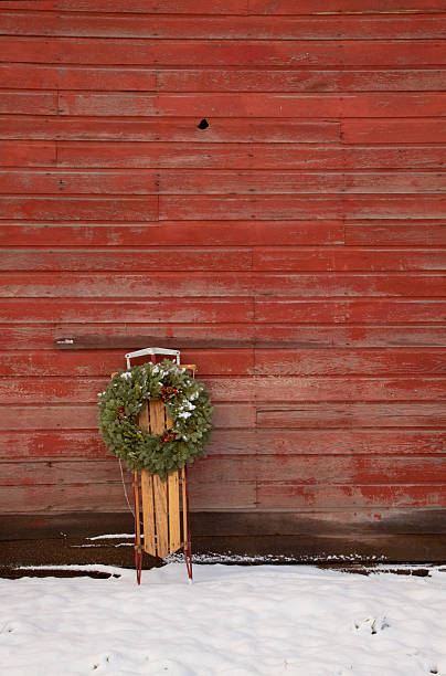 Old Sled Against Red Barn stock photo