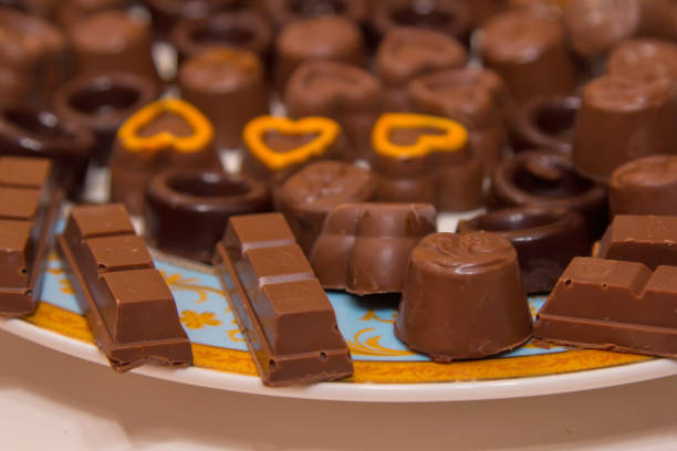 Close up color image depicting a box of gourmet chocolate truffles of different shapes and different varieties of chocolate. Selective focus with room for copy space.