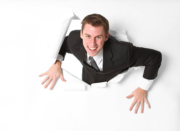istock Happy businessman emerging through a hole in white paper 183337604
