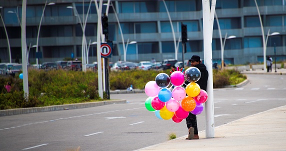 Beirut, Lebanon - 11 25 2023: a man selling balloons standing on the site of a road in Beirut waiting for customers