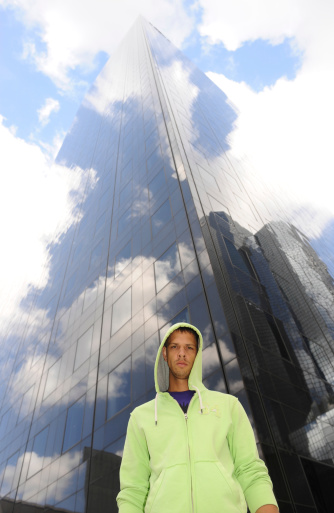Attractive young man in front of a skyscraper that blends with clouds