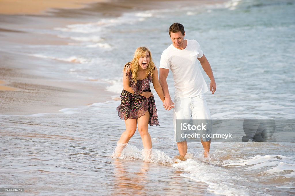 Couple marchant et en tenant les mains sur la plage - Photo de Adulte libre de droits