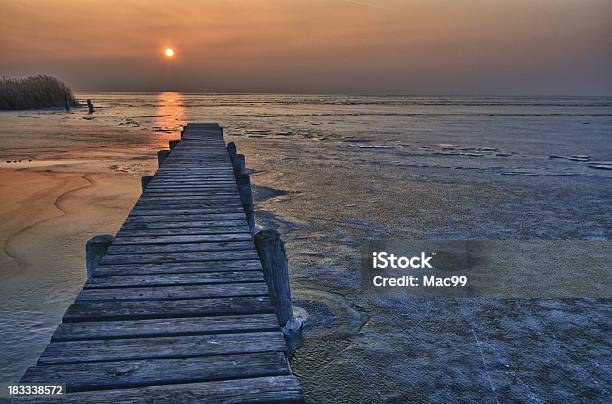 Molo Sul Lago Ghiacciato In Ultimo Luce Solare - Fotografie stock e altre immagini di Acqua - Acqua, Alba - Crepuscolo, Ambientazione esterna