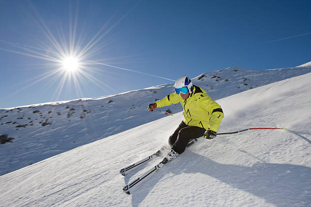 skifahrer fahren einen berg vor der sonne. - carving skiing stock-fotos und bilder