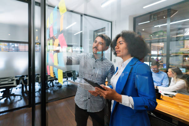 Business team brainstorming at the office and writing ideas on sticky notes
