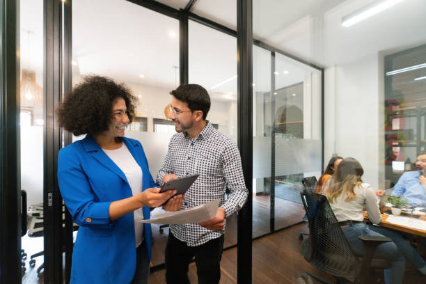 istock Two coworkers sharing ideas at the office and smiling 1833393694