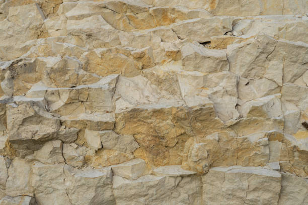 istock Background from natural limestone stone. Beautiful light limestone stone with cracks and broken pieces of rock. Background from wild limestone stone. 1833397385