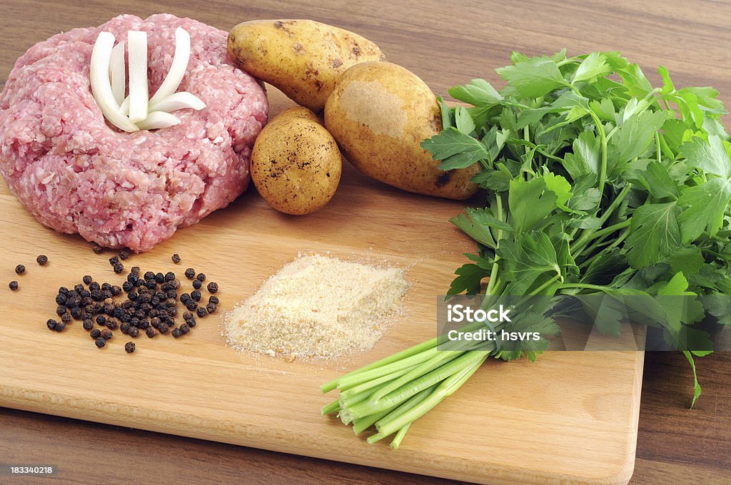 Ground meat in form of Hedgehog breadcrumbs onions pepper parsley "minced meat , Ground meat in form of Hedgehog with fresh ingedients like breadcrumbs onions pepper and bundle of parsley with raw potatoes" Backgrounds Stock Photo