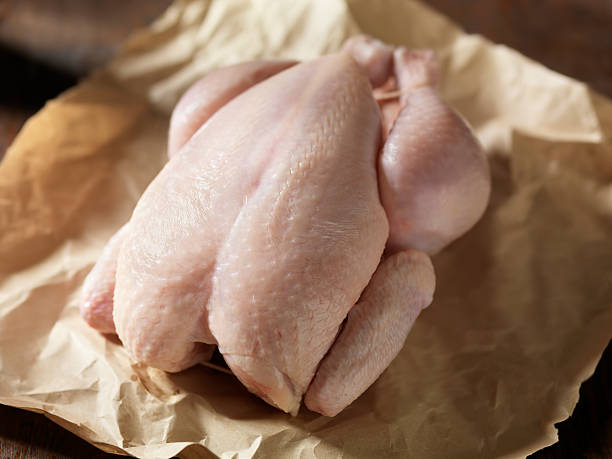 Raw Chicken in Butchers Paper Raw Chicken in Butchers Paper-Photographed on Hasselblad H3D2-39mb Camera chicken meat stock pictures, royalty-free photos & images