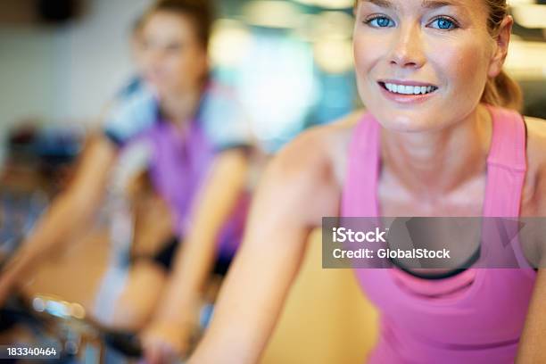 Mujer Haciendo Ejercicios Durante Clase De Spinning Foto de stock y más banco de imágenes de 20 a 29 años