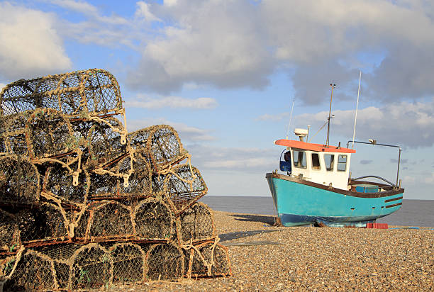 Beach at Aldeburgh, Suffolk "Fishing boat and lobster pots on the beach at Aldeburgh, Suffolk" suffolk england stock pictures, royalty-free photos & images