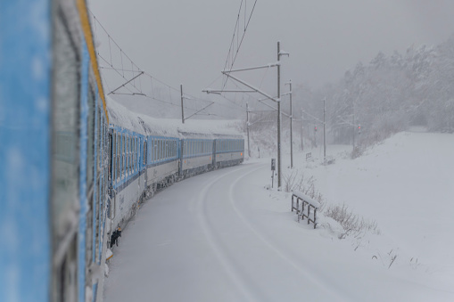 Electric trains near deep snowy forest in Chotycany CZ 12 02 2023