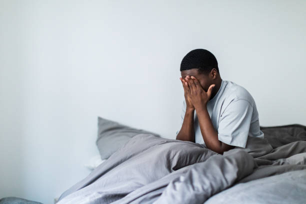 istock Depressed young black men sitting in bed 1833413805