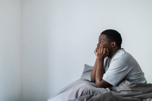 istock Depressed young black men sitting in bed 1833414318