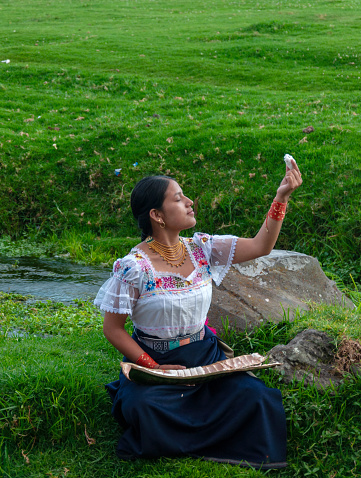 young indigenous girl making an offering to mother nature of the first guaba of the year's harvest, guaba day. High quality photo