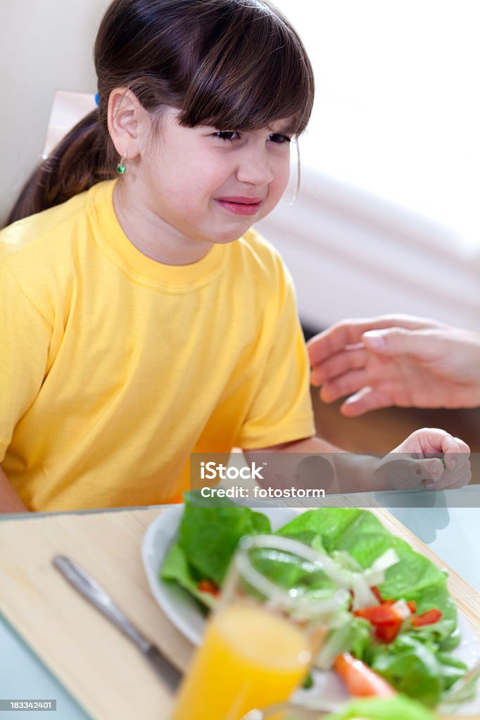 Menina chorando na mesa, não quer comer legumes - Foto de stock de Alimentação Saudável royalty-free