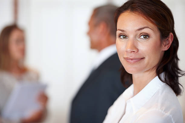 istock Confident businesswoman with colleagues behind 183342563