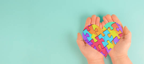 istock ASD autism spectrum disorder, deficits in social communication and interaction, hands holding heart with colorful jigsaw or puzzle pieces 1833428074