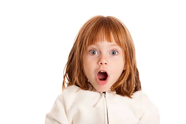 Color photo of a little 4-5 year old girl gasping with a look of surprise on white background.