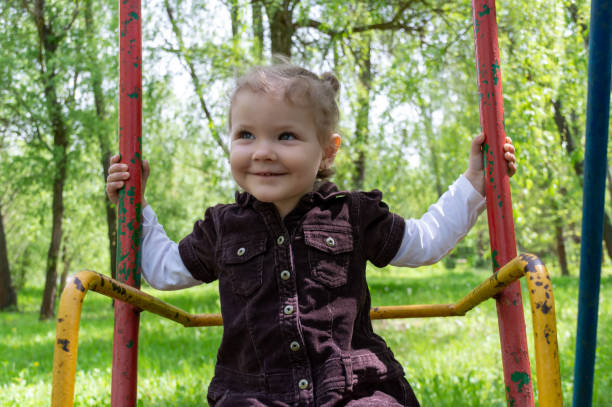 Smiling cute girl riding on a swing