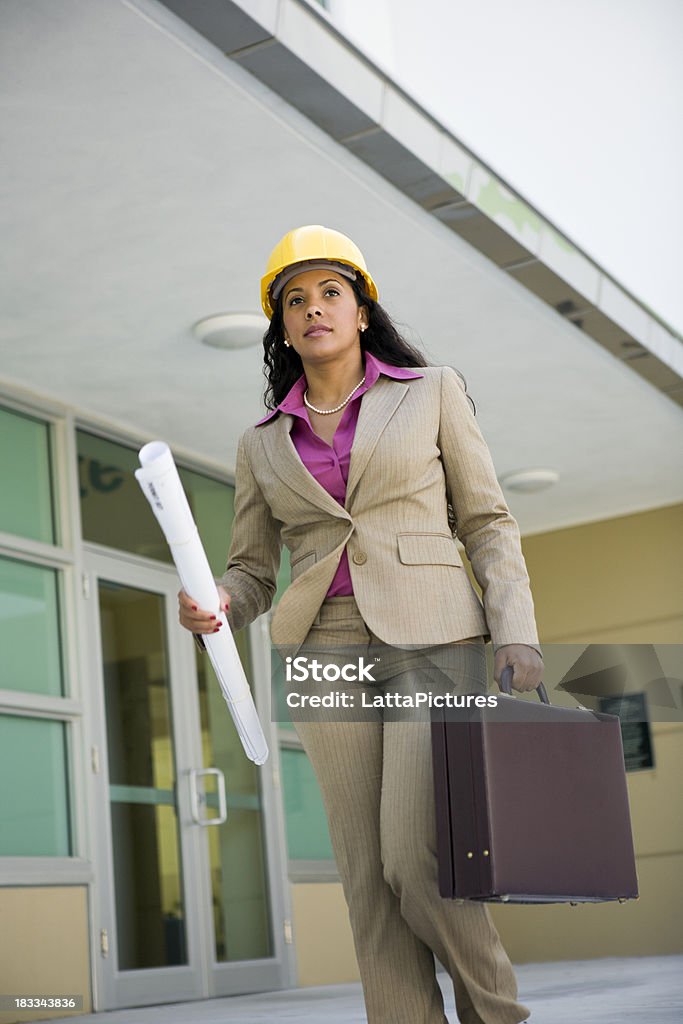 Mujer sostiene blueprints casco duro resistente a maletín de transporte - Foto de stock de Andar libre de derechos