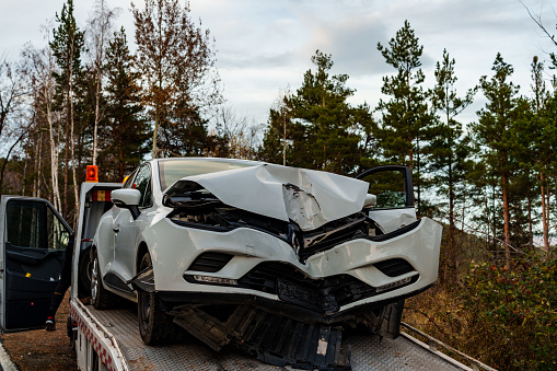 Ardino, Bulgaria - 2nd December, 2023 : Rental Vehicle crashed to tree on country road in Between Ardino and Karzdhali, Rodophi Mountains and Car was loading  to Tow truck from and securing from wheels to be stable on road.