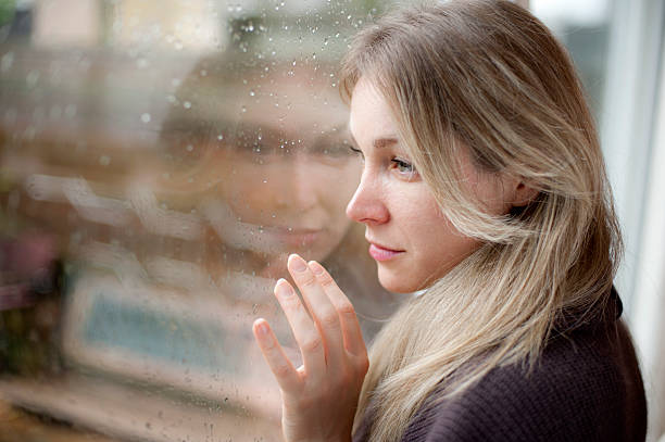 istock Blond sad girl on the window 183344921