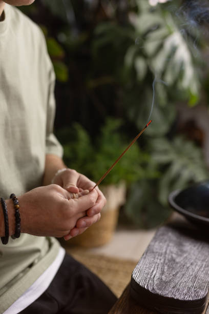 istock the guy holds aroma sticks in his hand and meditates 1833449318