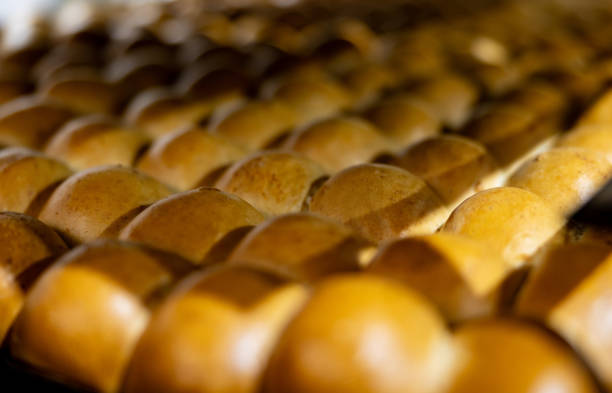 Close-up on loafs of bread at an industrial bakery fresh from the over