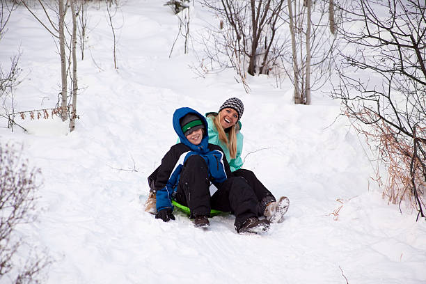 istock Mother and son playing on snow sled 183345671