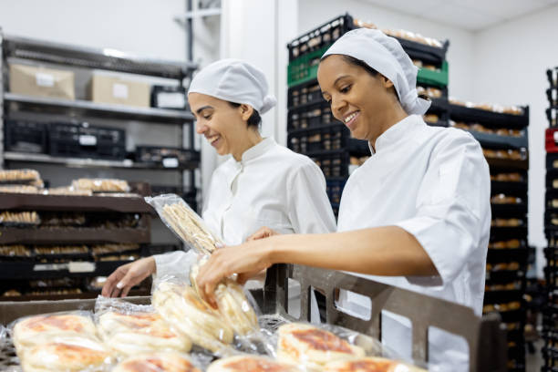 istock Women working at an industrial bakery doing quality control on packages of bread 1833456851