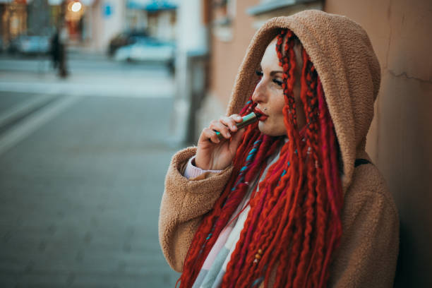 istock smoking an electronic cigarette on the street 1833456864