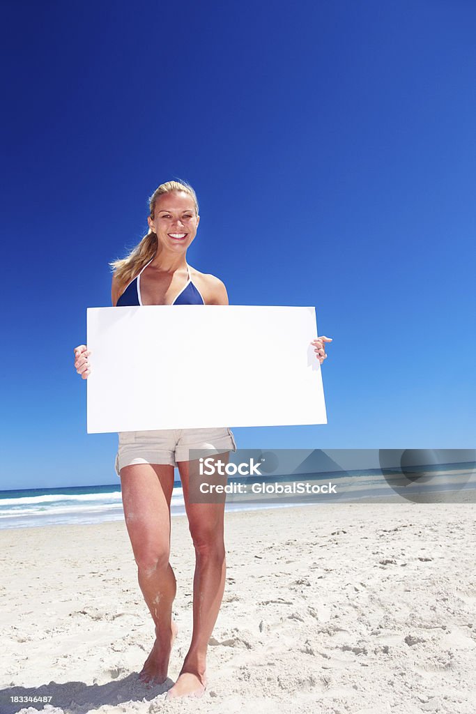 Feliz mujer sosteniendo un cartel en la playa - Foto de stock de Actividades recreativas libre de derechos