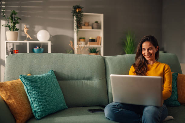 istock A happy woman is sitting at cozy home and using a laptop. 1833465593