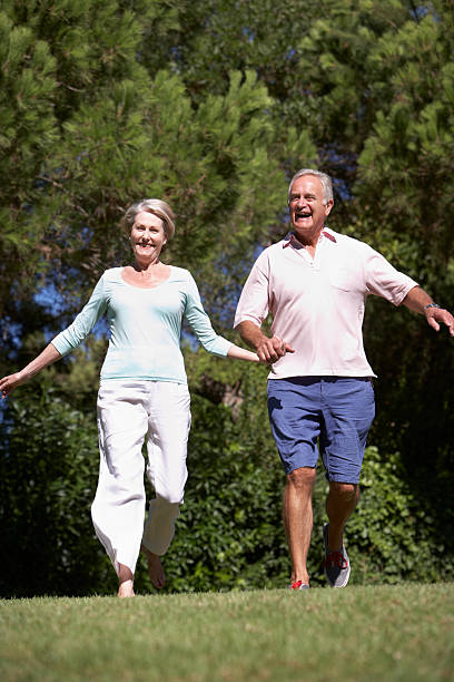 istock Senior Couple Running Through Summer Field 183347039