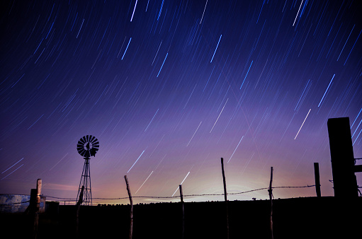 windmill silhouette long exposure photo with startrails
