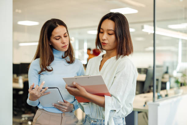 istock Multiracial business woman working together on a tablet and using a clipboard 1833471145