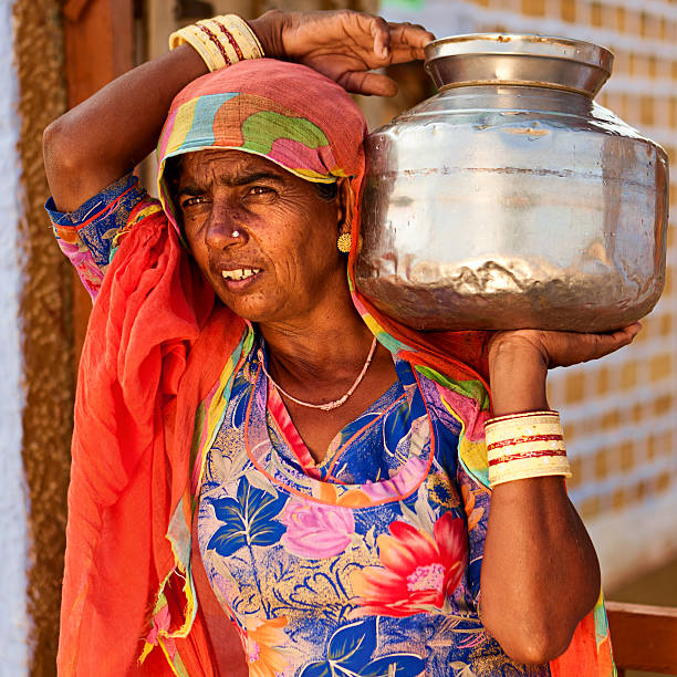istock Indian woman carrying water from well 183347244