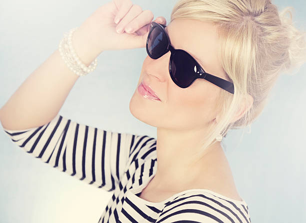 Attractive woman wearing Wayfarer- sunglases High key portrait  of a blonde attractive woman with light in background and Wayfarer- sunglases / cross processing hochsteckfrisur stock pictures, royalty-free photos & images