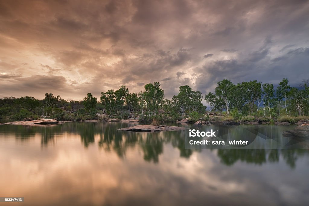 Billabong or small pond at Manning Gorge, Western Australia, sunset "Reflections in still water of a small lake with approaching storm clouds and thunderheads in the sky. Spectacular light at sunset. Shot at Manning Gorge, along the Gibb River Road, Western Australia." Australia Stock Photo