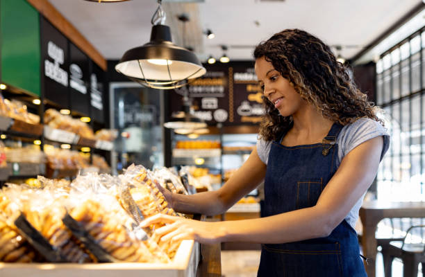 istock Business owner working at a bakery restocking the shelves 1833475924
