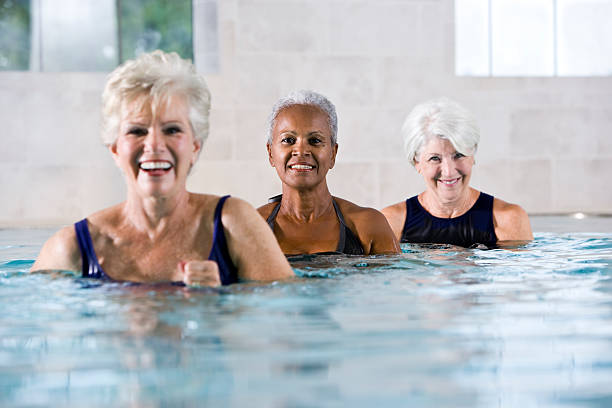 multiraciale femmes seniors à la piscine intérieure et centre de remise en forme et spa - sc0450 photos et images de collection