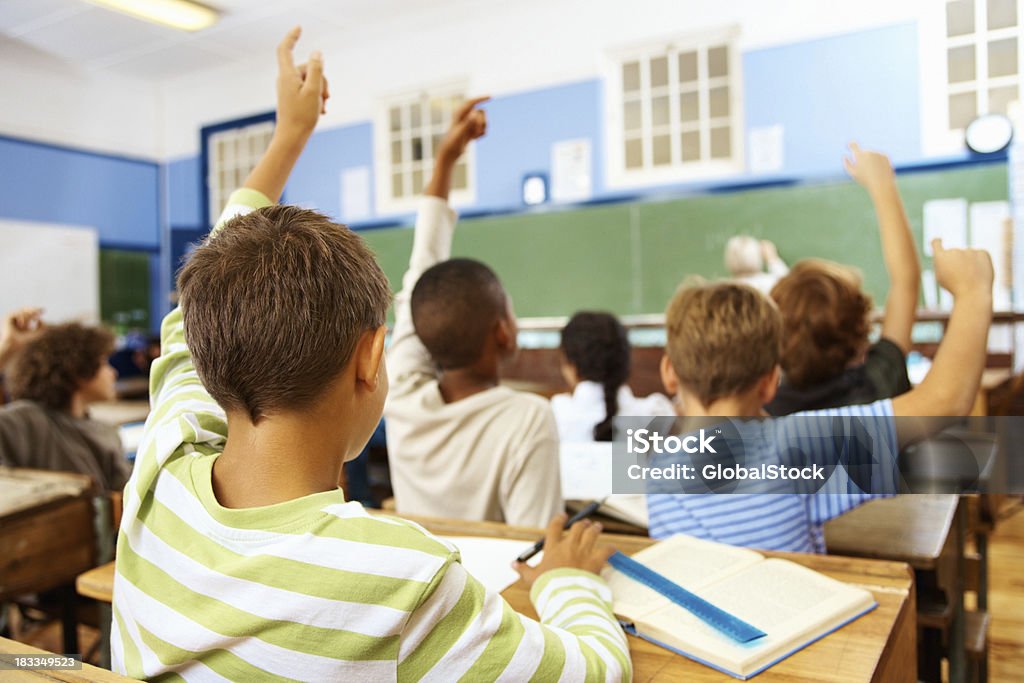 Vista posterior de un poco school boy en su montaje tipo aula - Foto de stock de Salón de clase libre de derechos