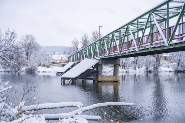 istock winter landscape with a snowy forest and an unfrozen river and bridge in. Czech. 1833498787