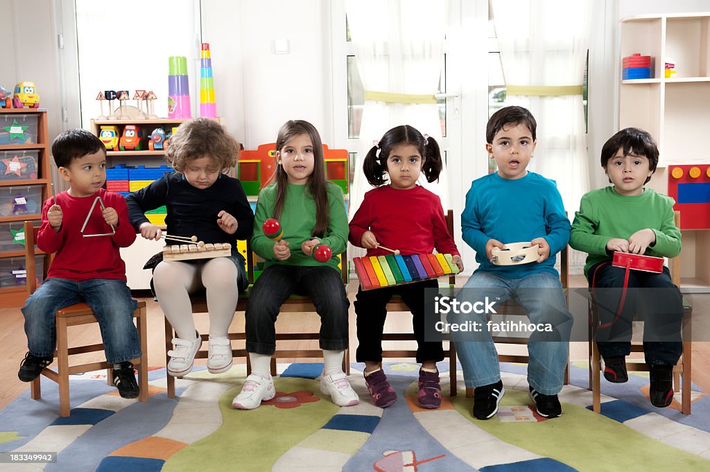 Preschool Children in a Music Class A group of preschool children in a music class. Playing Stock Photo