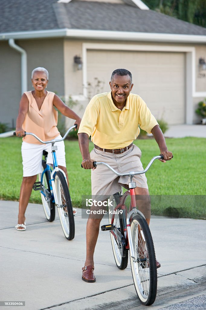 Senior African American couple riding bicycles, focus on man African Ethnicity Stock Photo