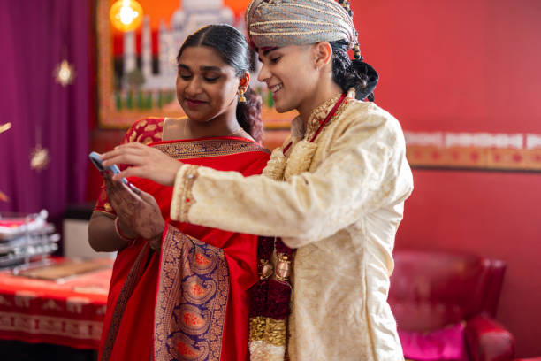 istock young indian couple in traditional clothes using smart phone 1833506208
