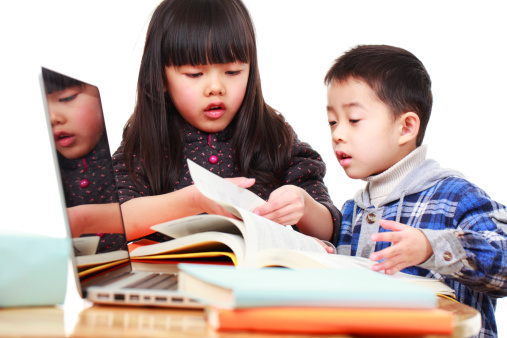 studio shoot of two asian kids study together