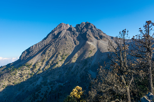 The peak of the nevado de colima on a clear blue sky.
