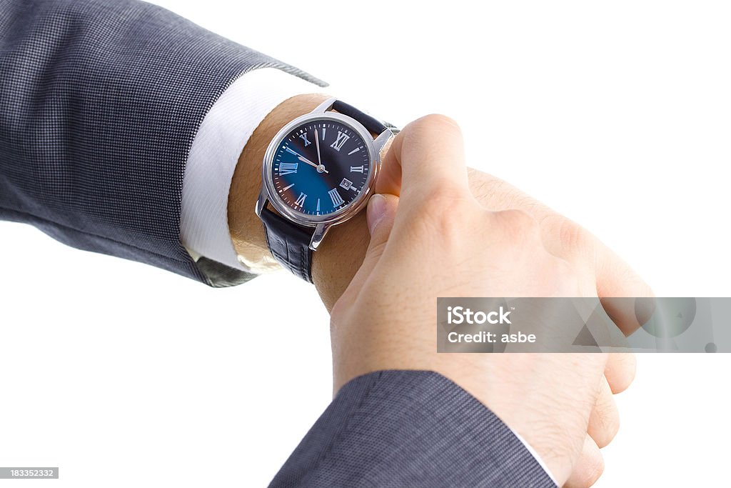 Businessman Checking his Watch Young man in suit setting his watch isolated on white Adult Stock Photo